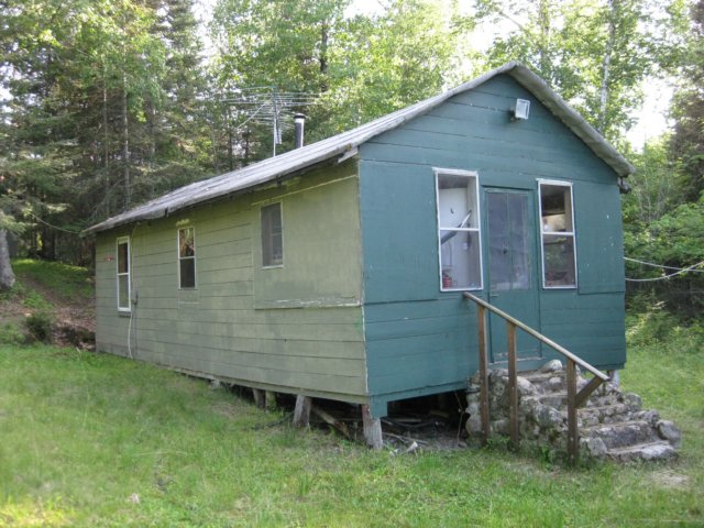 viewfromthenortheastbuiltin1915supportedbylarchpostssittingondirtwhatsactuallyholdingupthecabinafter95yearsarethefrontsteps.jpg